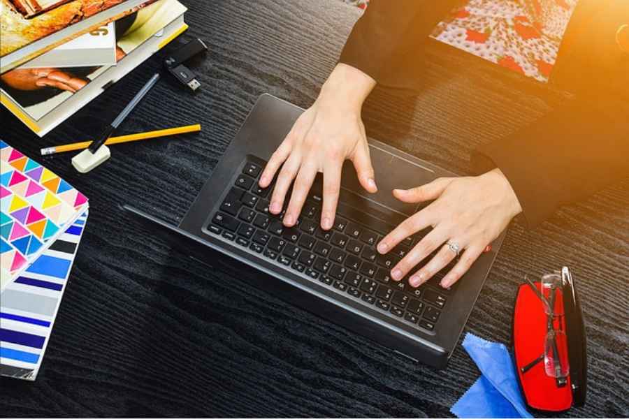 hands typing on a laptop