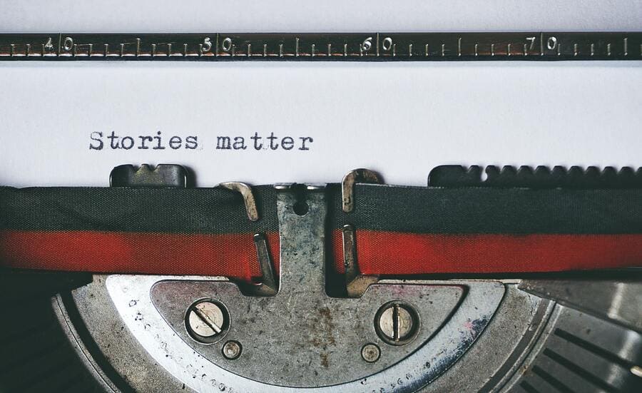 Close up of paper in typewriter that says "stories matter"